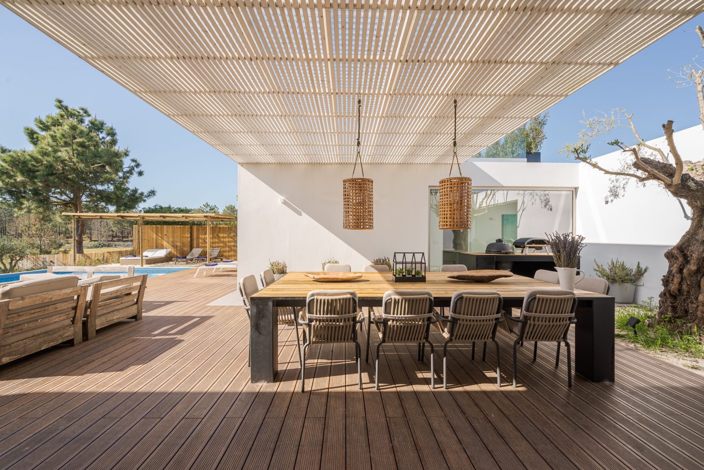 A white villa with a pergola, deck and pool in Ibiza